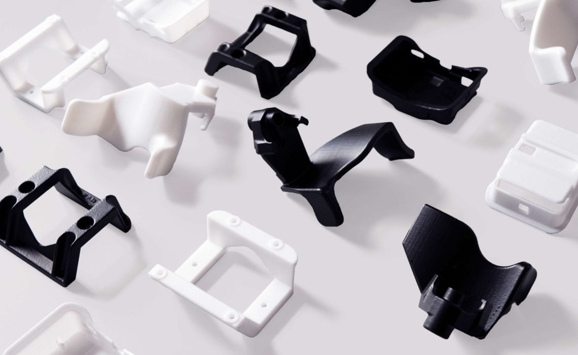 Nylon12-VersatilePlastic-White-Black-Smooth-Part-Flatlay-3Dprinting-Blog